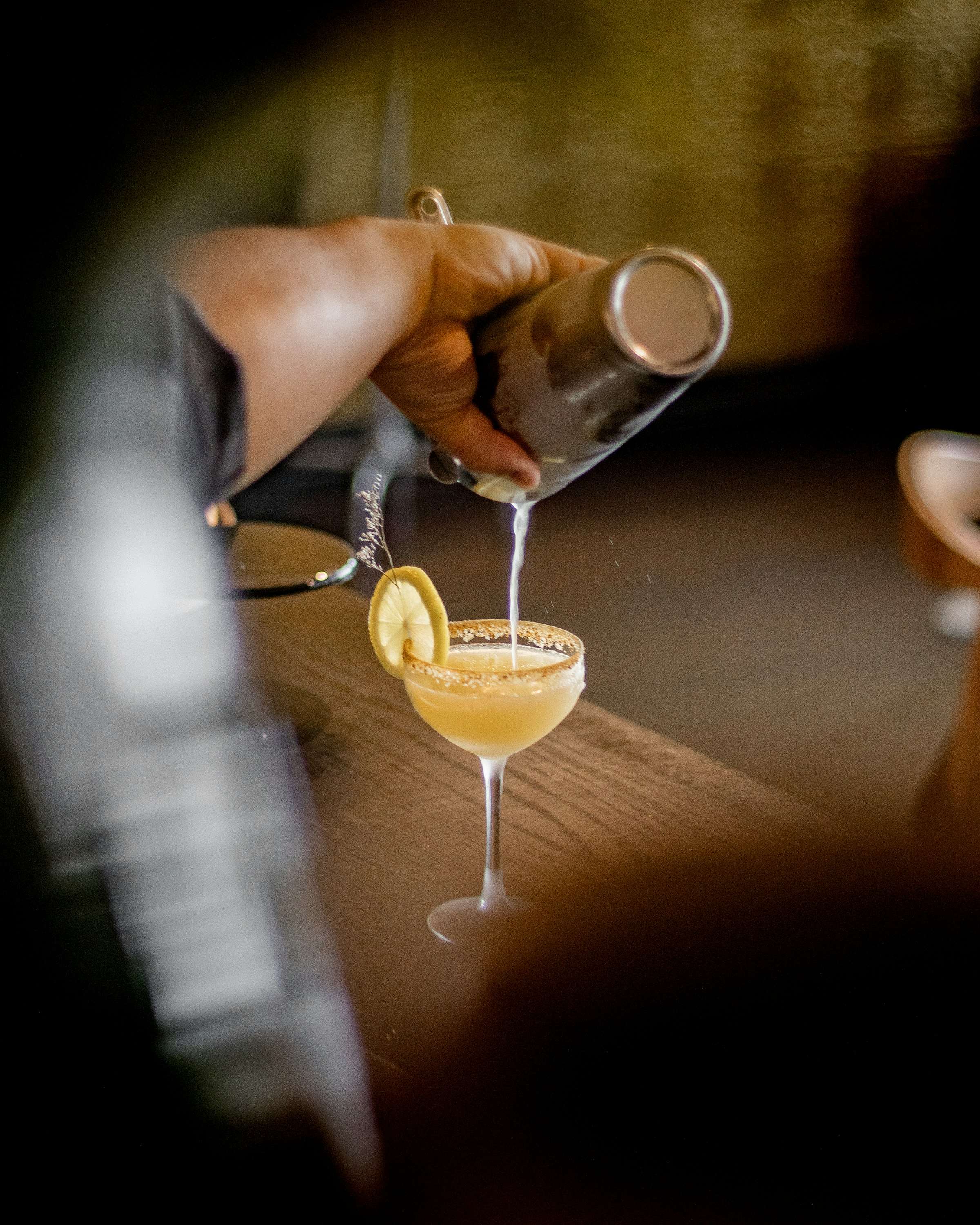 Drink wird an der Bar ins Glas gegossen