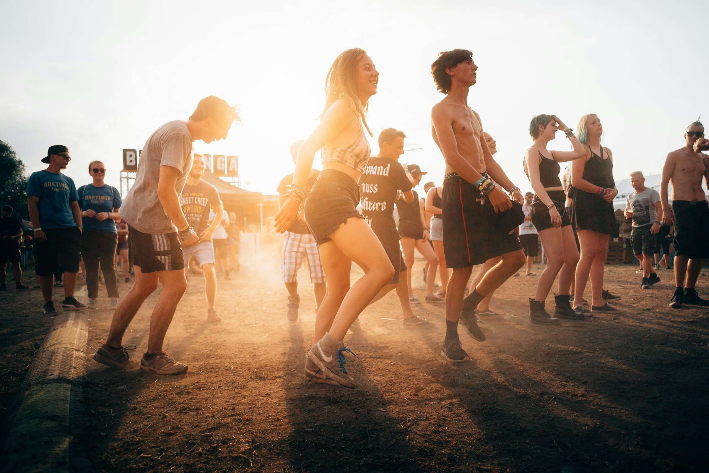 Menschen tanzen bei Sonnenuntergang auf einem Open-Air-Event