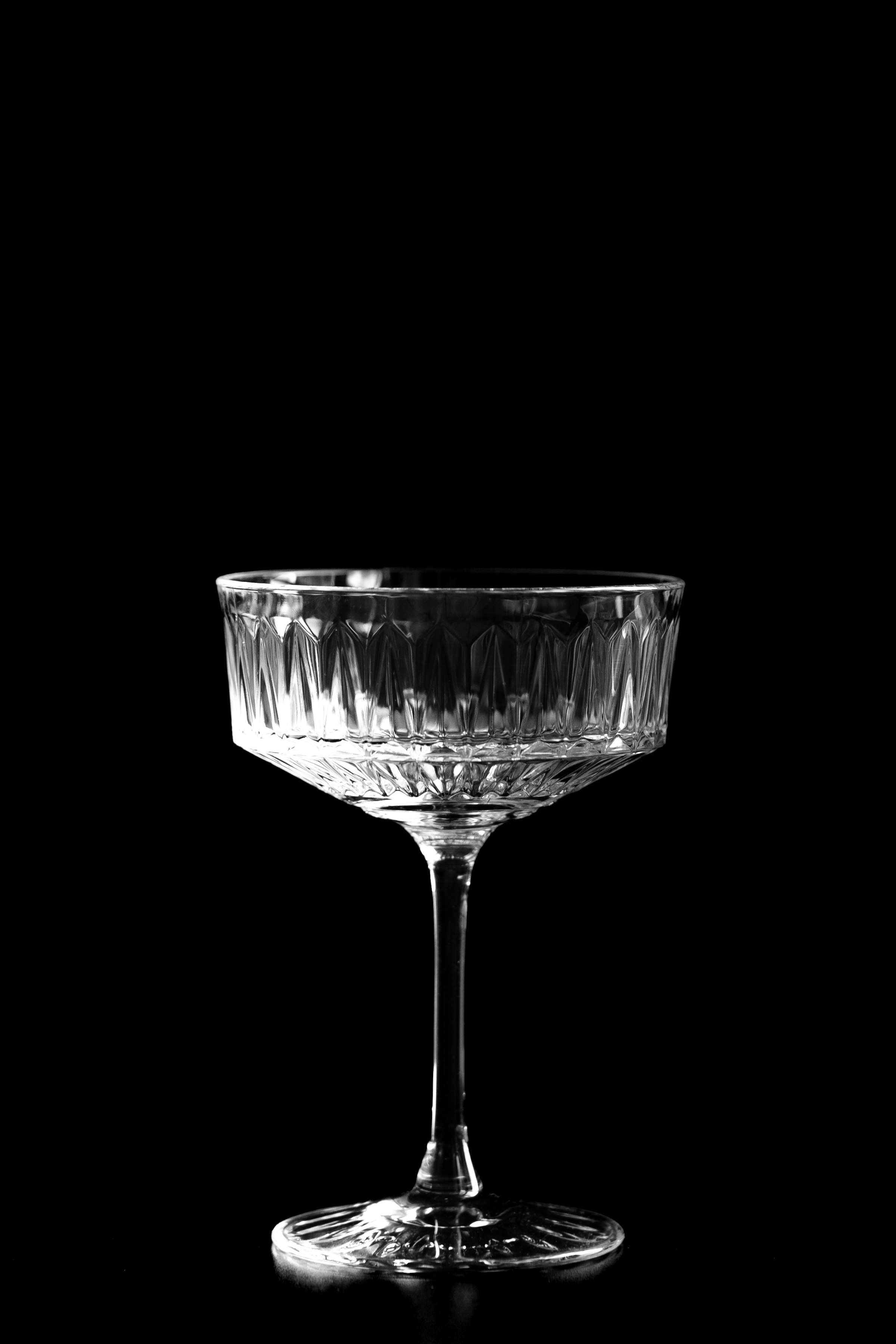 Cocktailglas vor schwarzem Hintergrund