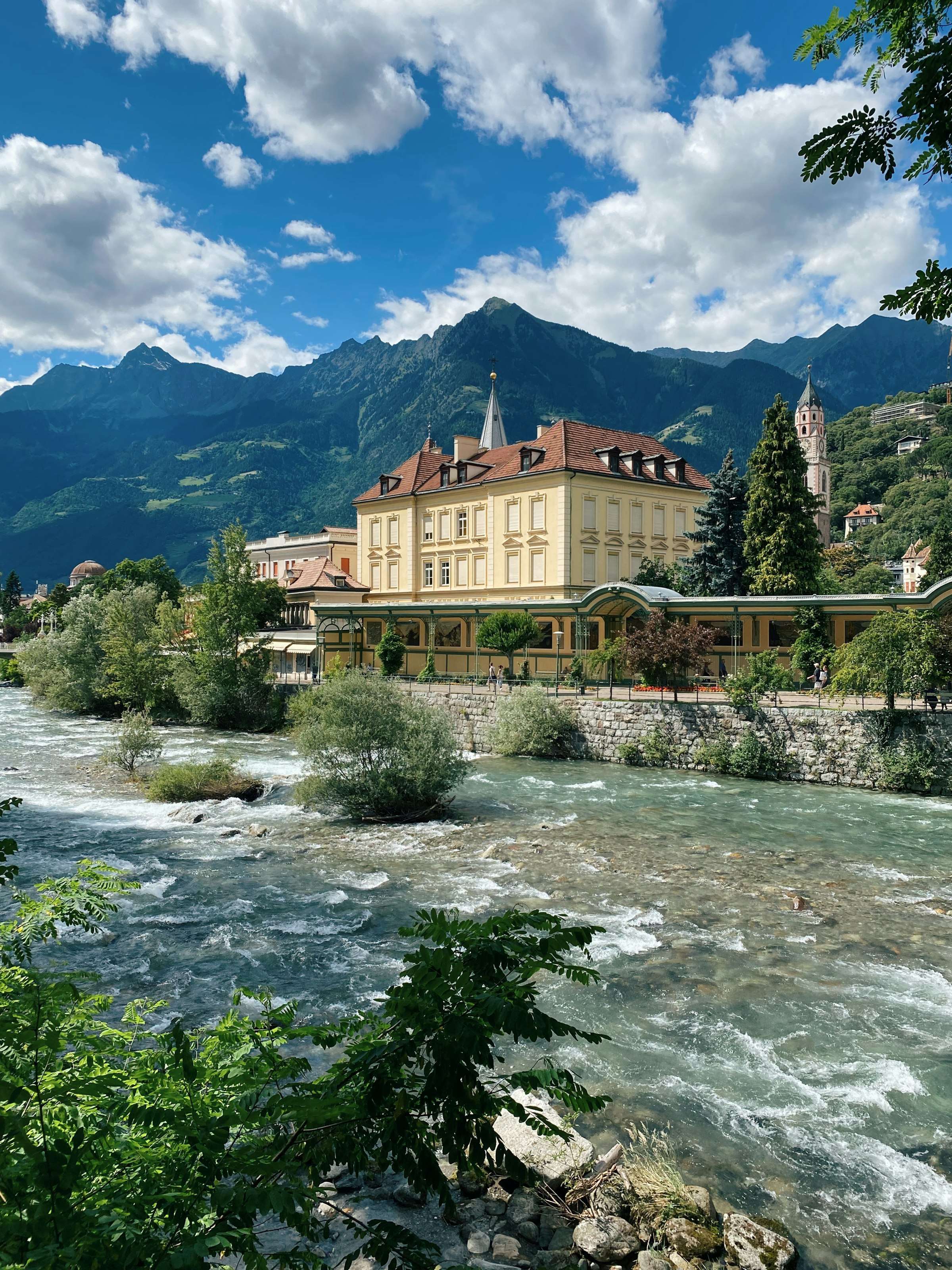 Häuser an der Passer in Meran mit Bergen im Hintergrund